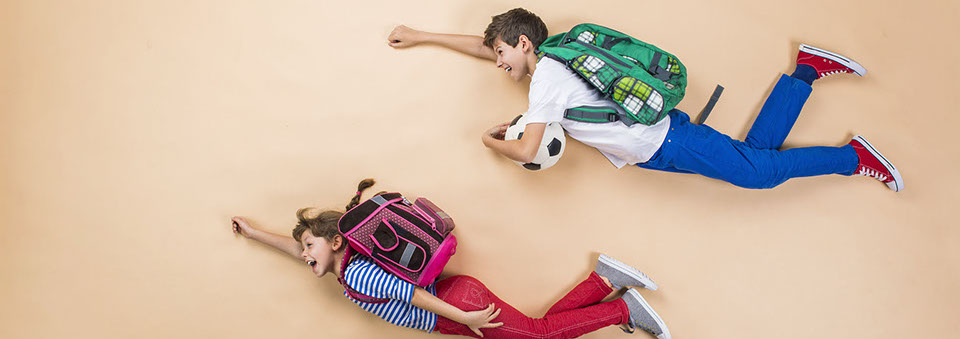 A boy and a girl on the floor pretending to fly