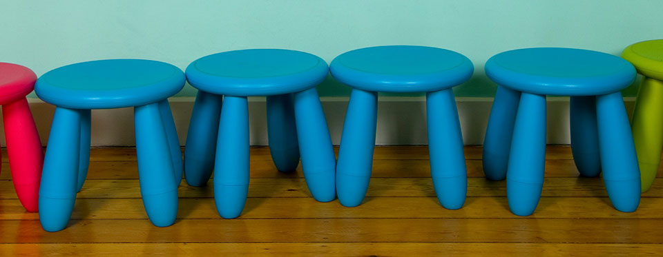 a row of small blue stools for children