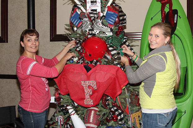 Two women decorating a tree for Festival of Trees