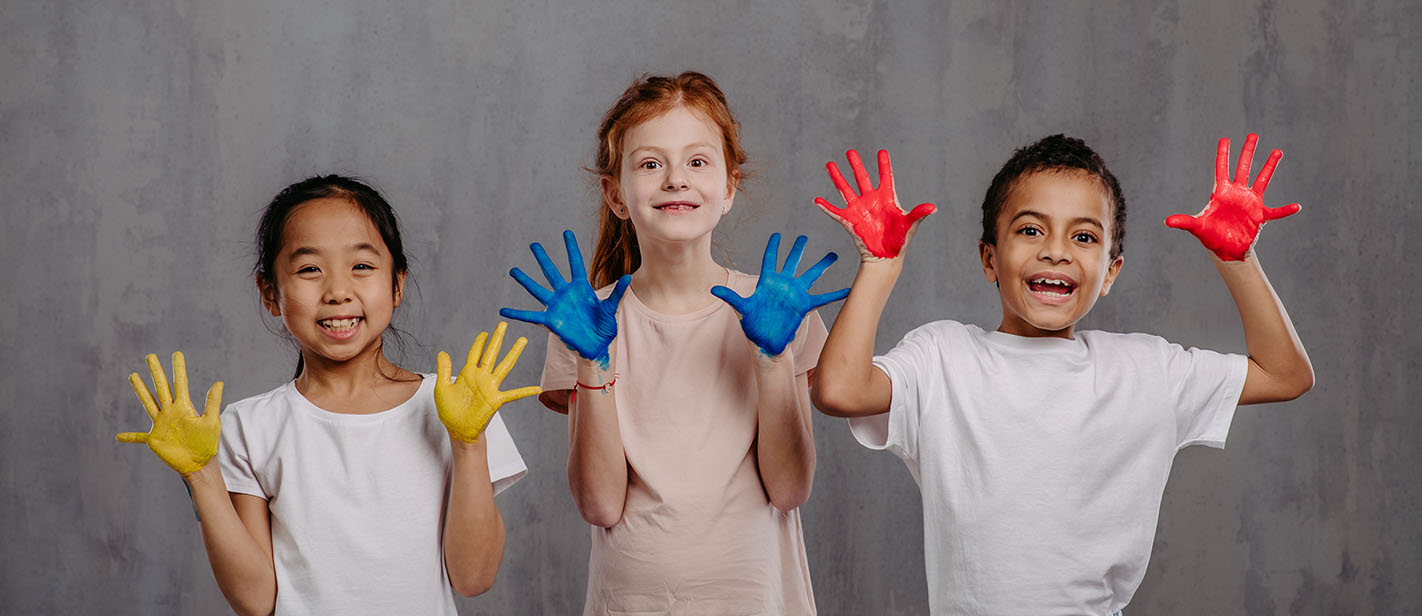 Portrait of happy kids with painted hands, studio shoot.
